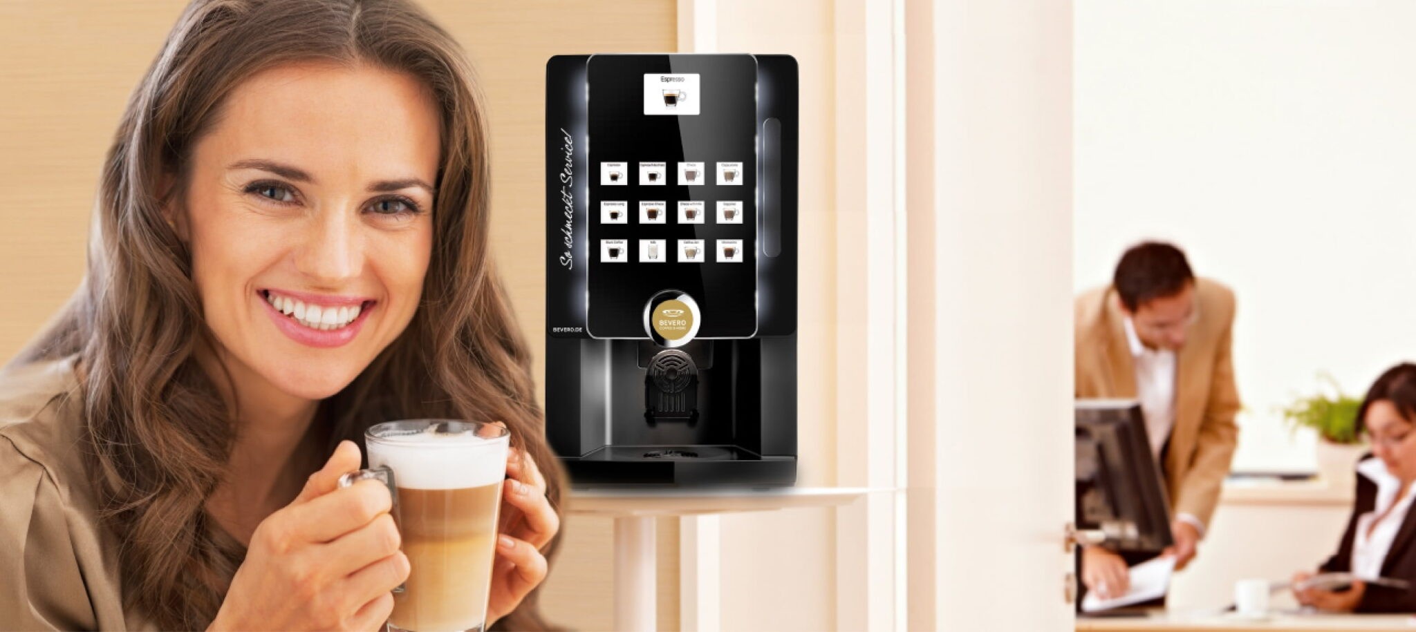 Frau lächelt und trinkt Latte neben Kaffeemaschine von Bevero